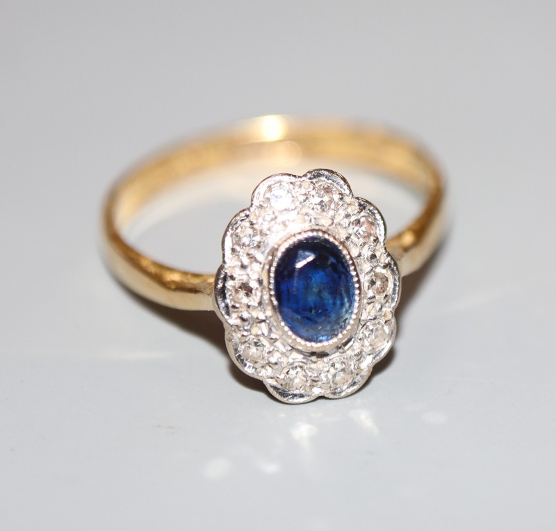 A modern 18ct gold and plat, sapphire and diamond oval cluster ring, size L, gross 2.6 grams.